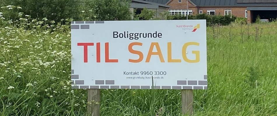 Billede. Til salg-skilt med kontaktoplysninger til kommunalt grundsalg